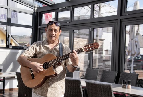 Musiker Toni Ierimonte mit Gitarre im Wintergarten des Pastori